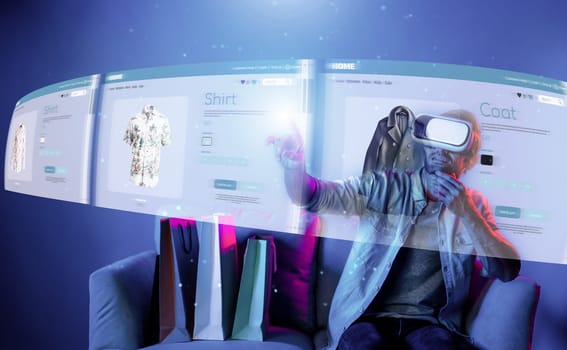 Caucasian man choosing and selecting product for shopping list while wearing visual reality goggles. Skilled person sitting at sofa with shopping bags while using VR glasses. Technology. Deviation.
