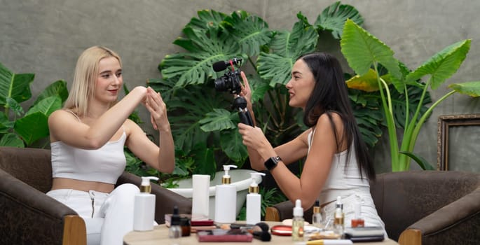 Two beautiful content creator making natural beauty and cosmetic tutorial on green garden. Beauty blogger show how to beauty care video to social medial audience using selfie stick.Panorama Blithe