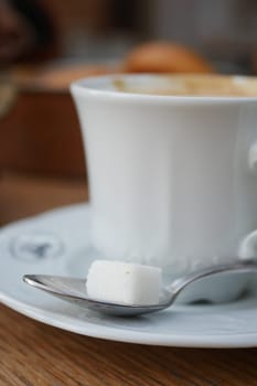 cup of tea and sugar cube on table with copy space