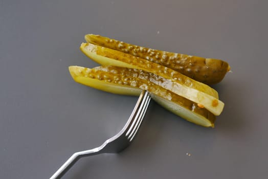 a close up of a pickle on a plate with tomatoes,