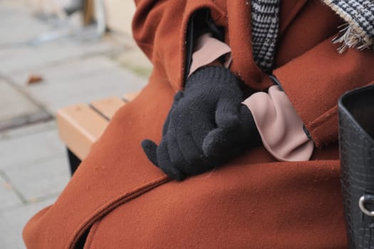 woman hands put on warm gloves on a winter cold day