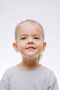 Portrait of a little smiling girl on a gray background. High quality photo