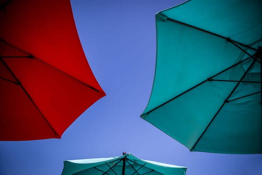 Vibrant Trio of  Umbrellas in the Clear Blue Sky
