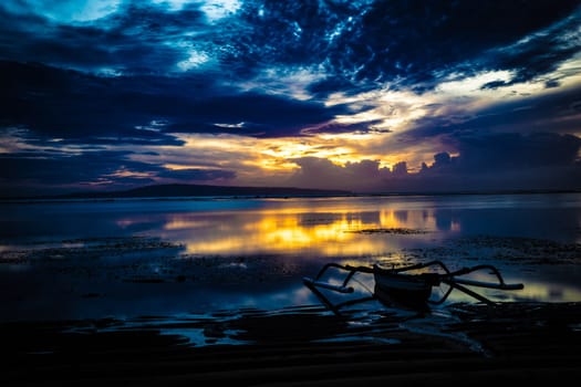 Indonesian Sunrise with a fishing boat on shore