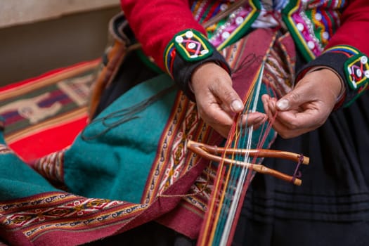 A Peruvian woman weaving a scarf by hand