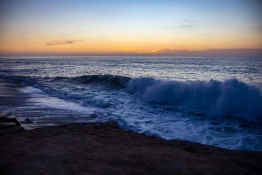 Weaves crashing into the shore during sunset