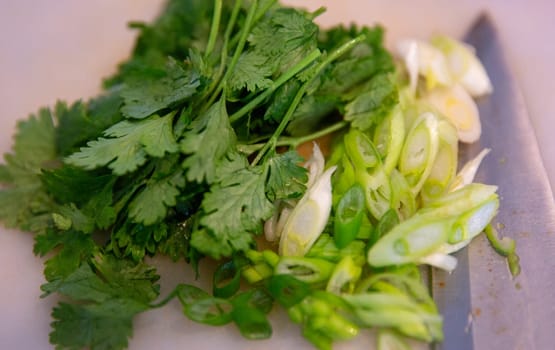 Cilantro and sliced green onions with a knife