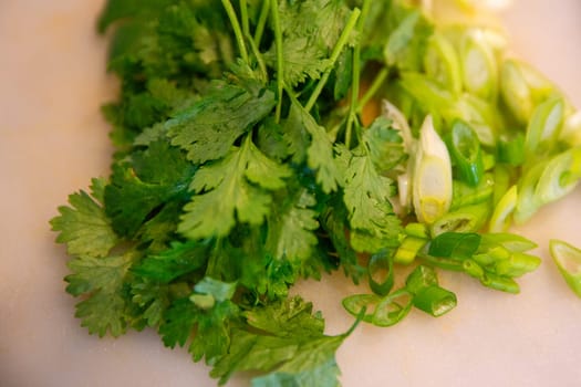 cilantro and green onion with a knife next to them