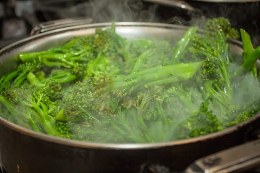 Steaming broccolini in a pot at a restaurant