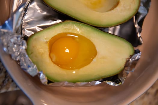 raw egg in an avocado ready to be baked