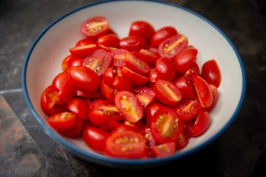 Bowl of small red sliced tomatoes