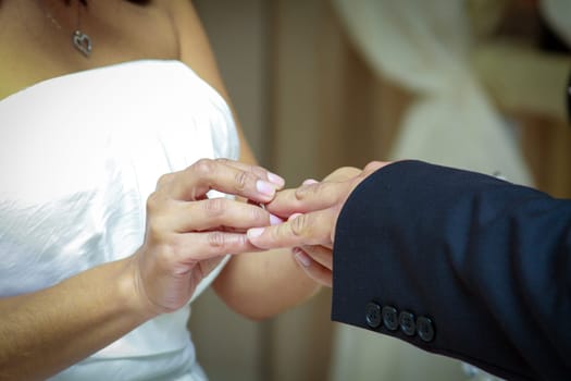 Bride placing ring on groom at the ceremony