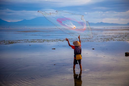 Indonesian Fisherman Throwing a Net to get fish for his village