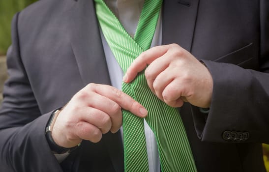 Man putting his tie on getting ready for his event