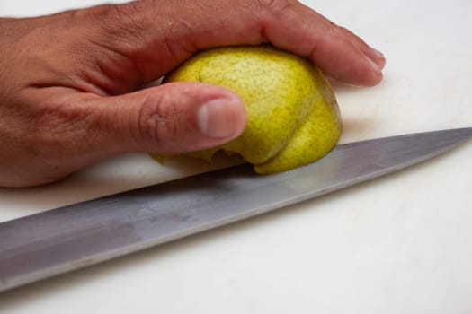 Slicing a pear for a meal preparation