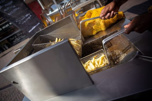 Frying freshly cut fries at a market to snack on