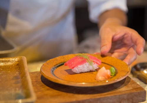 Japanese chef serving sushi shot close up