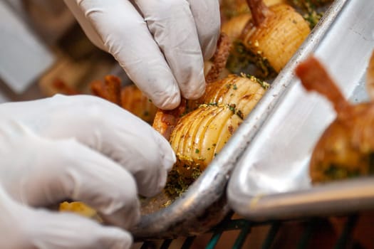 Decorating small potato appetizers to be set up for a catering event