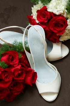 Red roses and off white bridal shoes