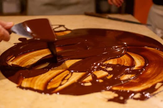 Chocolatier spreading chocolate as a demonstration