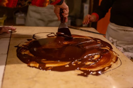 Chocolatier spreading chocolate as a demonstration