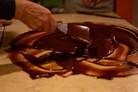 Chocolatier spreading chocolate as a demonstration