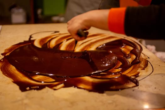 Chocolatier spreading chocolate as a demonstration