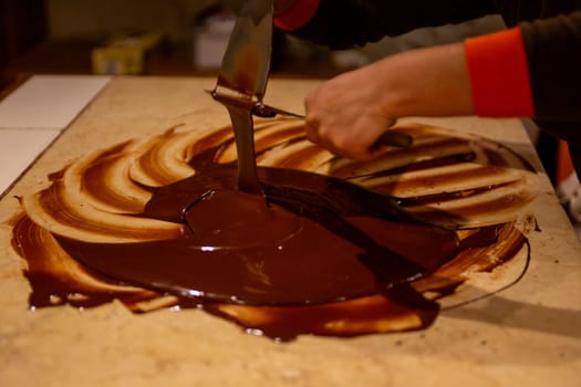 Chocolatier spreading chocolate as a demonstration