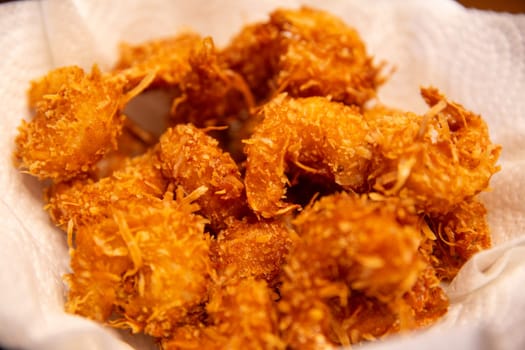 Fresh Fried Coconut Shrimp cooling on a napkin