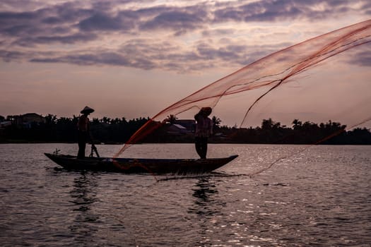 Vietnamese fisherman throwing a net to catch food for the village