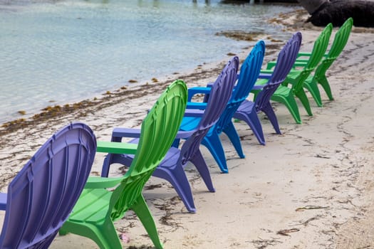 Multicolored beach chairs on the shore for people to sit on