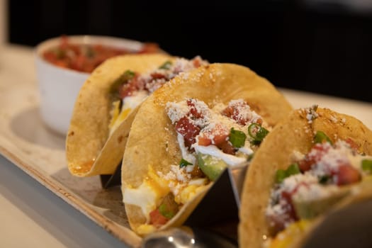 Breakfast tacos in corn tortilla topped with cheese