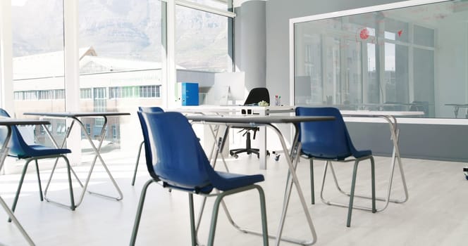 Empty, classroom and clean furniture with board for exam, test or setup of chairs, desks or interior. Indoor venue, layout or preparation of space for study, lesson or row with seats in arrangement.