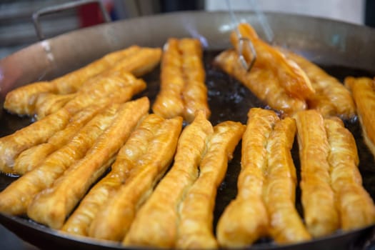 Frying fresh chinese donuts at the market