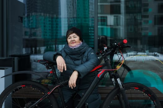 Mature European woman sat down to rest during a bike ride around the city.