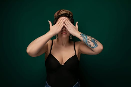 A woman sitting with her hands covering her eyes in a gesture of blocking out light or shielding herself from a bright or overwhelming situation. She appears to be seeking privacy or taking a moment to collect her thoughts.