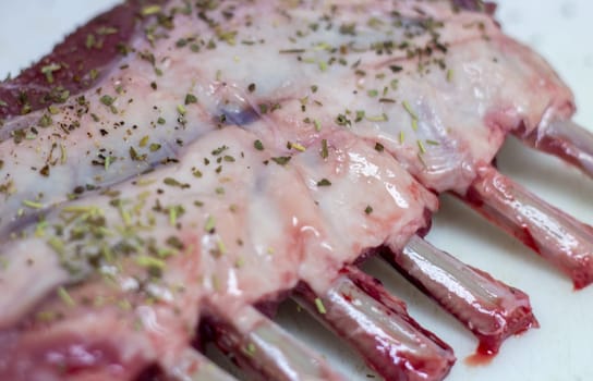 Uncooked Rack of Lamb seasoned with spices