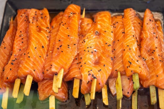marinated salmon on a stick ready to be cooked