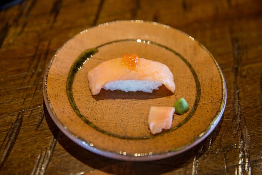 Salmon sushi with roe on top with ginger and wasabi