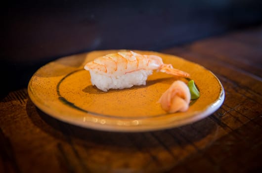 Shrimp sushi on a plate with wasabi and ginger