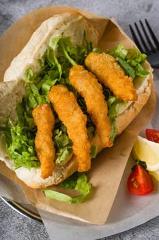 Deep fried shrimp in bread with greens on the side. Shrimp sandwich