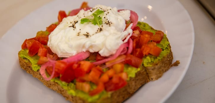 Avocado and egg toast with pickled onions and tomatoes