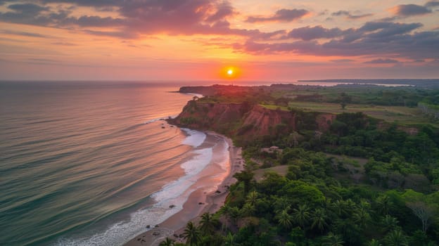 A view of a sunset over the ocean and lush green vegetation