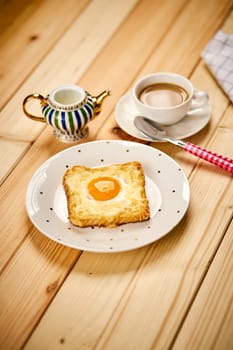 Delicious breakfast set with coffee and toast with fried egg on wooden kitchen table