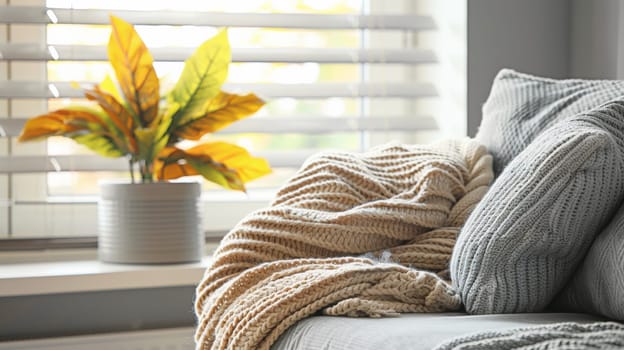 A couch with a blanket on it next to some plants