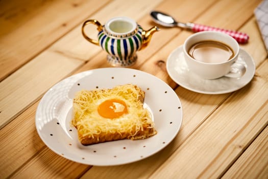 Delicious breakfast set with coffee and toast with fried egg on wooden kitchen table