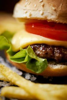 delicious cheeseburger on a black table with salt crystals