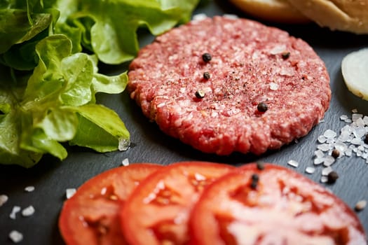 fresh beef for burger on the table with lettuce, onion and bread