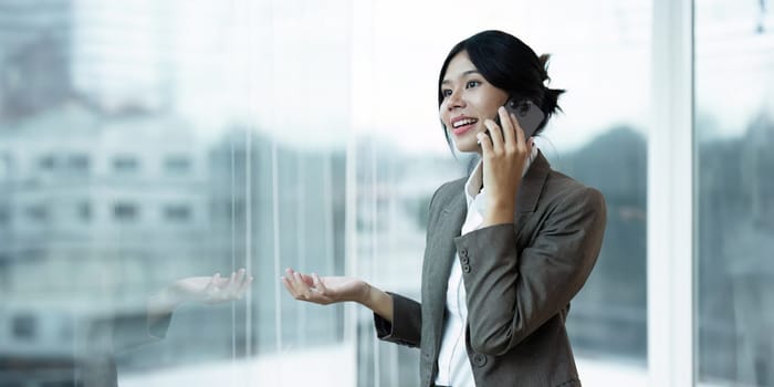 happy professional business woman talking on mobile with partnership at work standing at lobby.