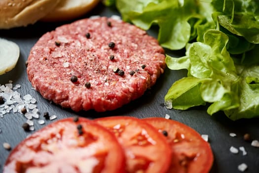 fresh beef for burger on the table with lettuce, onion and bread